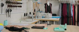 workshop of tailor studio tailoring wear to order interior of small fashion studio view of rolls of fabric spools of thread and patterns free photo